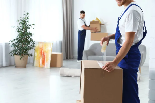 depositphotos_277757532-stock-photo-moving-service-employee-sealing-cardboard